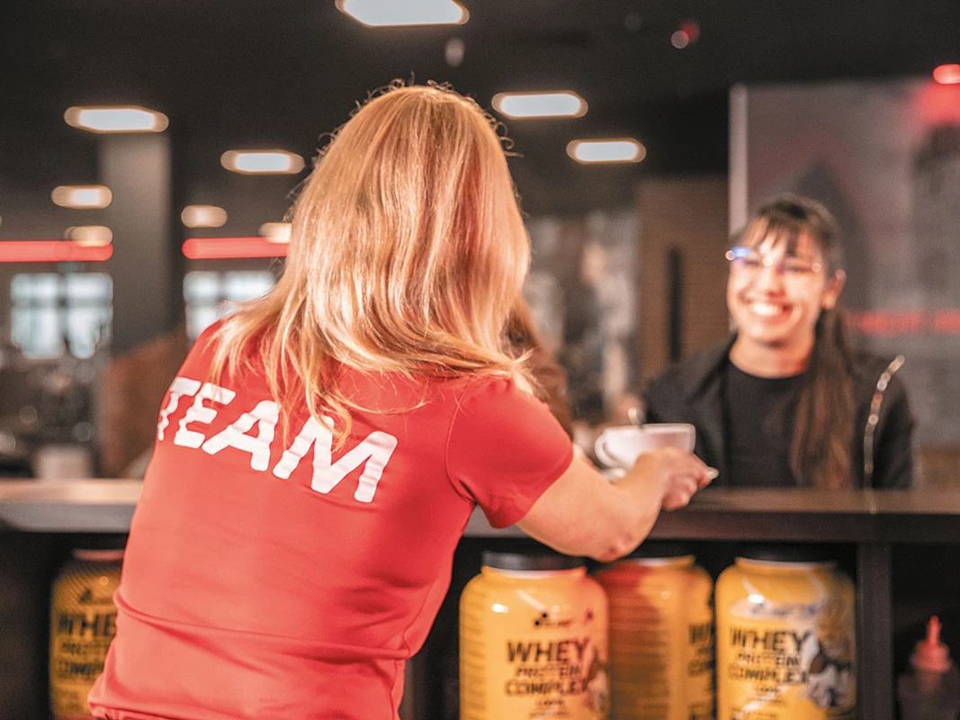 Mitarbeiter serviert Proteinshake an Theke