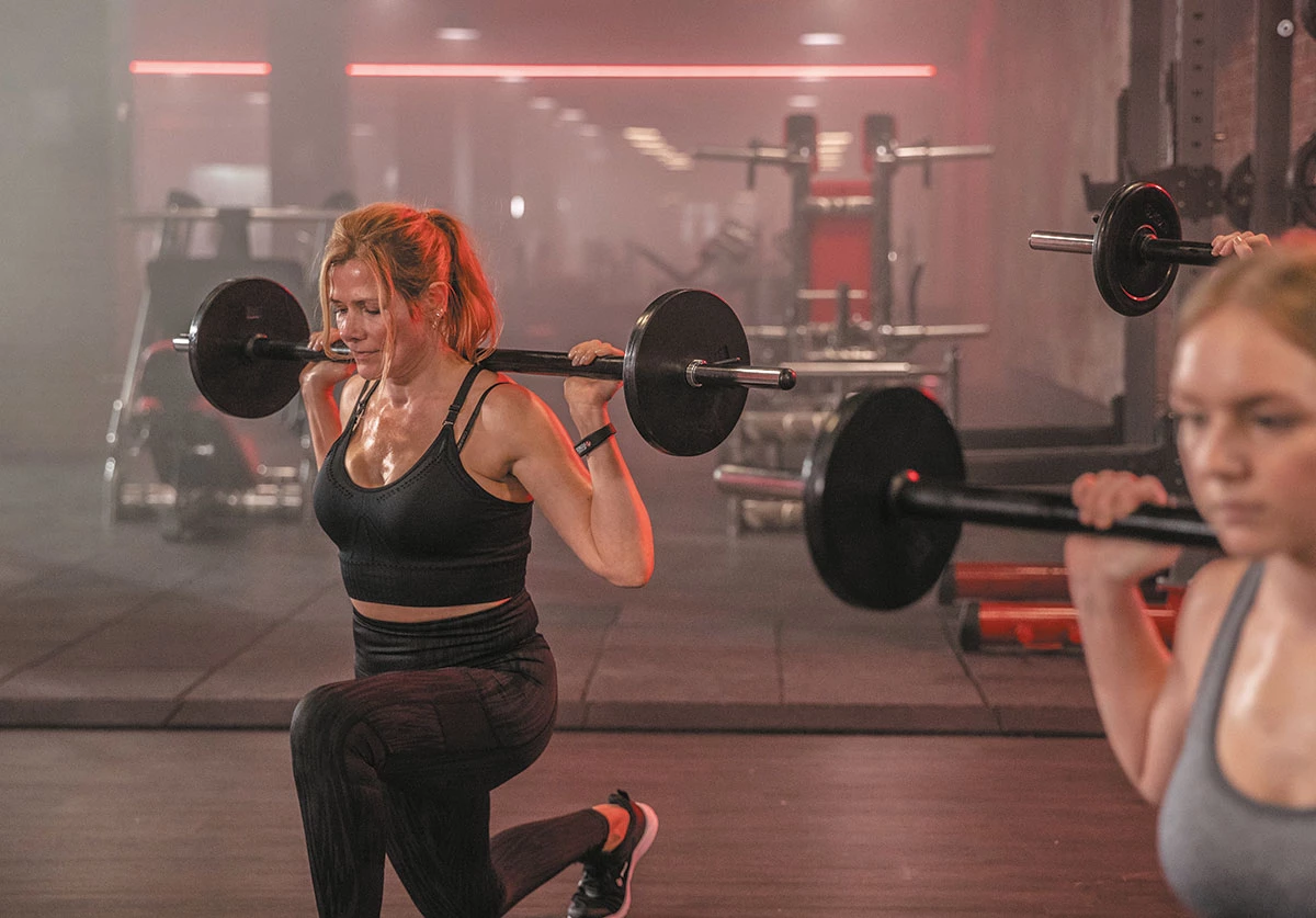 Frauen trainieren mit Langhanteln im Fitnesskurs – effektives Krafttraining in der Gruppe bei all inclusive Fitness