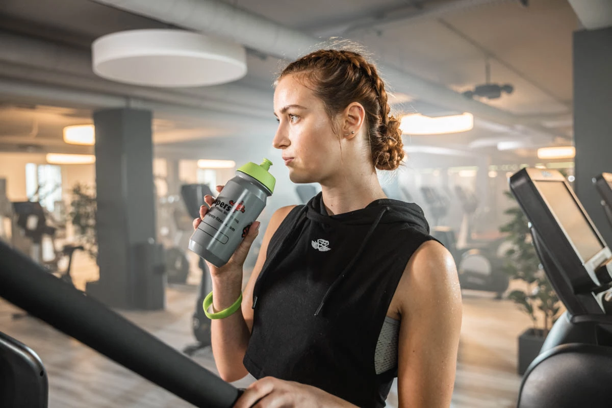jumpers Mitglied trinkt etwas im Fitnessstudio