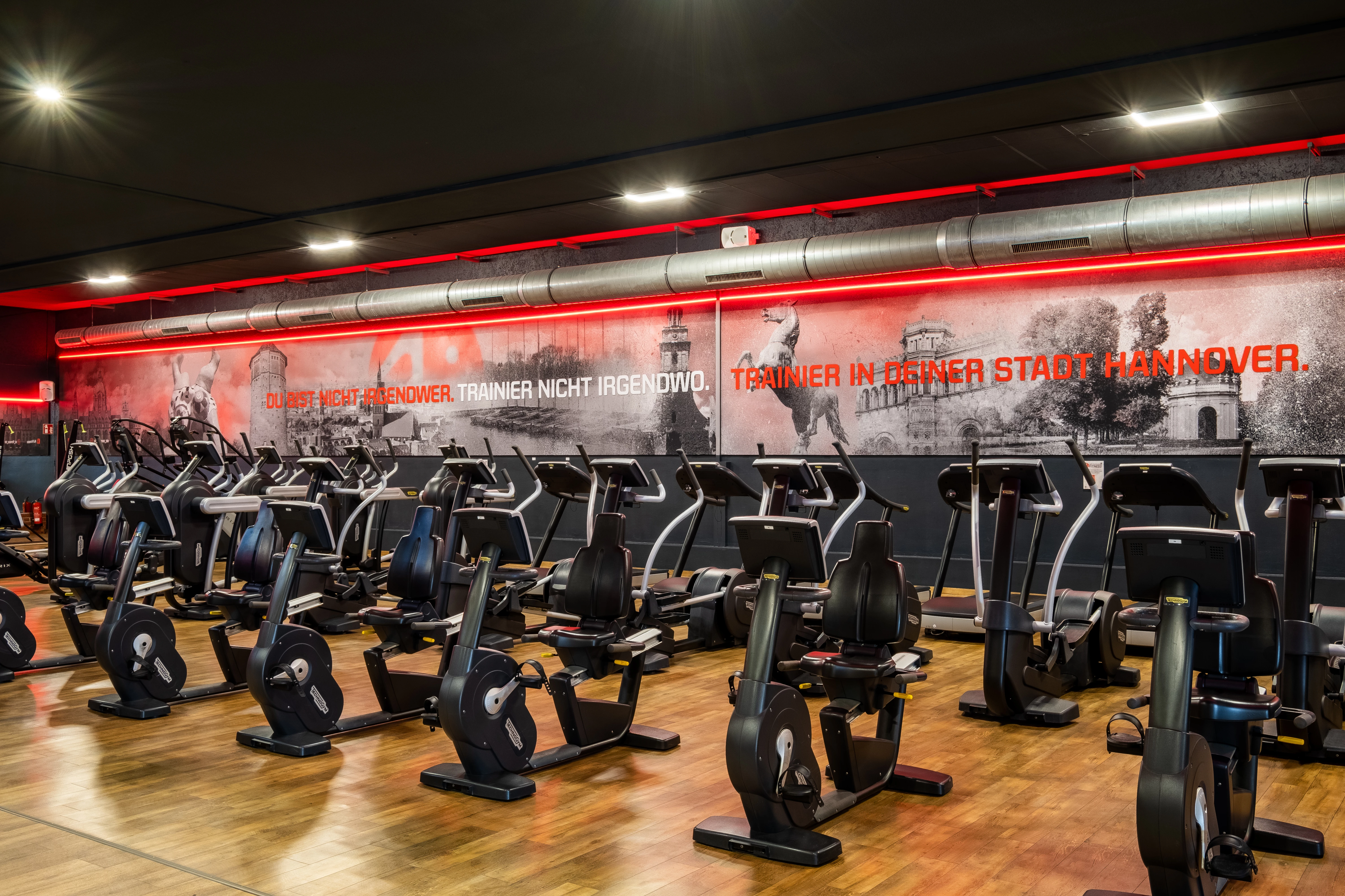 Fitnessstudio mit Trainingsgeräten. Text: ‚11 weitere Studios – all inclusive Fitness übernimmt die Kette Fitness Future.