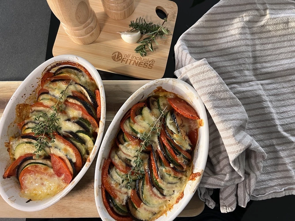 Große Servierplatte mit Käse, Aufschnitt, frischem Gemüse wie Tomaten, Gurken, Spinat, Kräutern, Feigen, Erdbeeren und Heidelbeeren sowie einem Brötchen. Daneben kleine Schälchen mit weiteren Zutaten