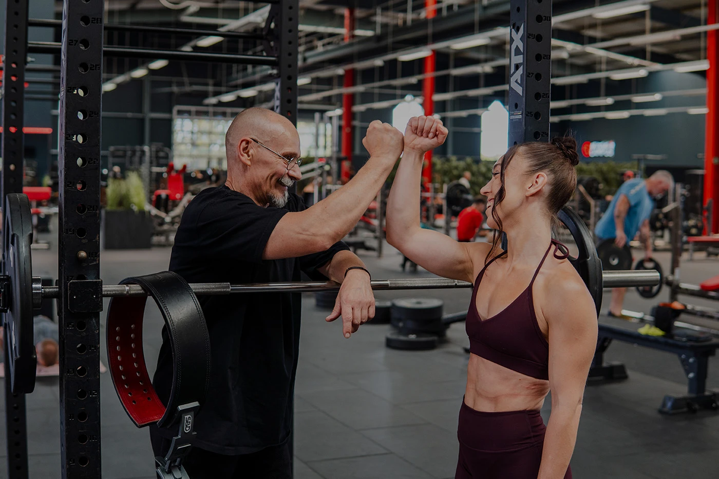 Zwei Personen trainieren zusammen an einem Kraftgerät im Fitnessstudio