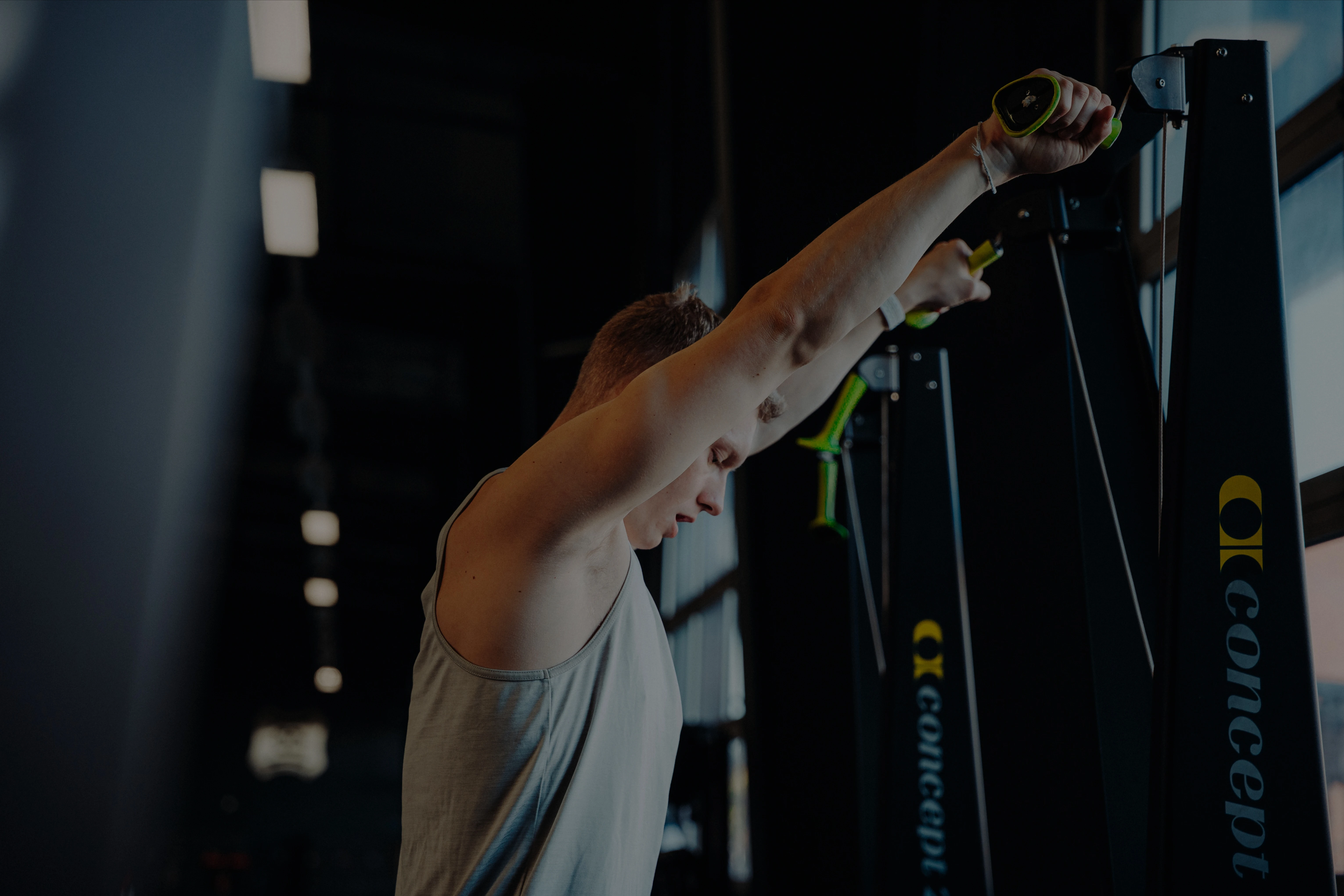 Zwei Personen trainieren zusammen an einem Kraftgerät im Fitnessstudio