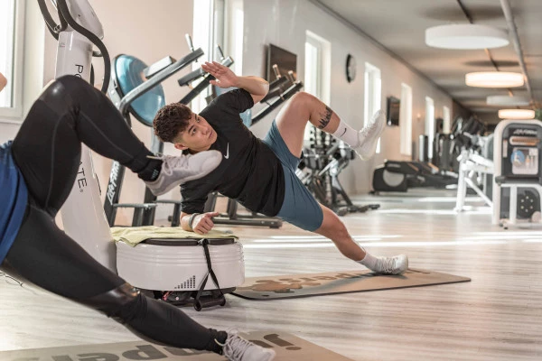 jumpers fitness Vibrationstraining Frau mit Trainerin auf Power Plate